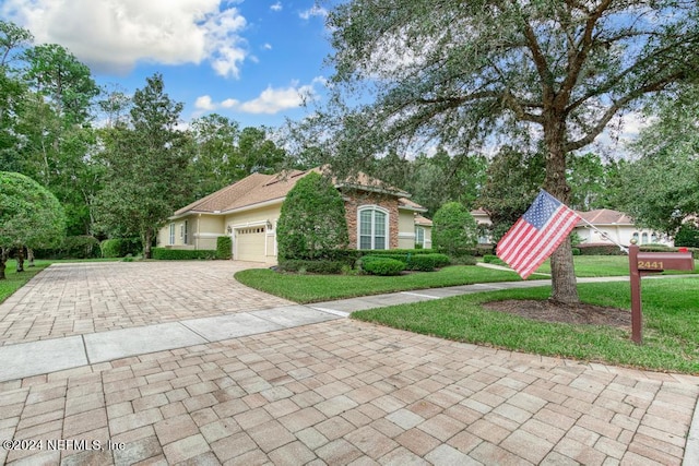 view of front of property with a front yard and a garage