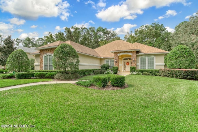 mediterranean / spanish-style house featuring a front lawn