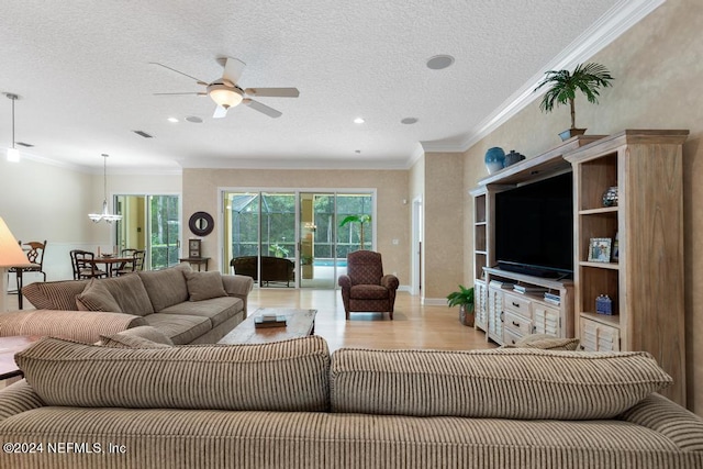 living room with ornamental molding, a textured ceiling, and ceiling fan with notable chandelier