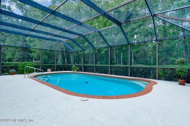 view of swimming pool featuring a patio area and a lanai