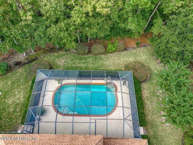 view of pool with a yard and a lanai