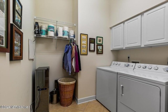 laundry area with light tile patterned floors, cabinets, and washing machine and clothes dryer