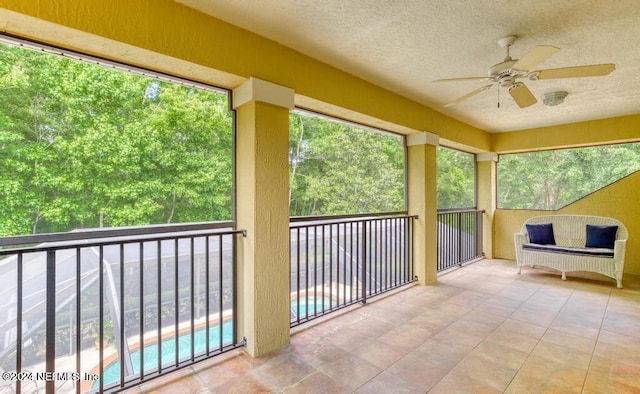 unfurnished sunroom featuring ceiling fan