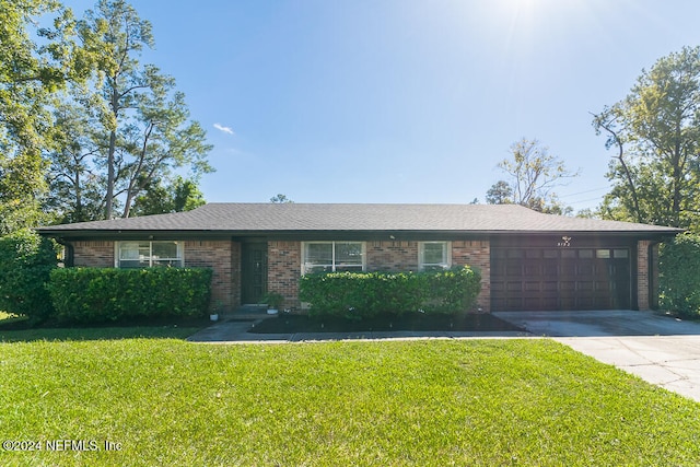 ranch-style house featuring a front yard and a garage