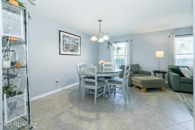 dining space featuring light tile patterned flooring, a notable chandelier, and plenty of natural light