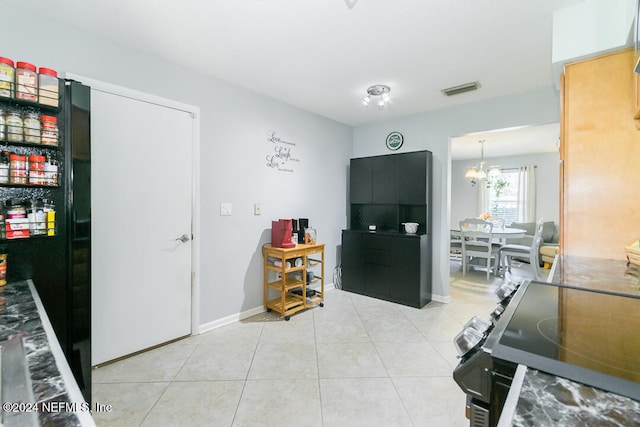 interior space featuring a notable chandelier, light tile patterned floors, and stainless steel range oven