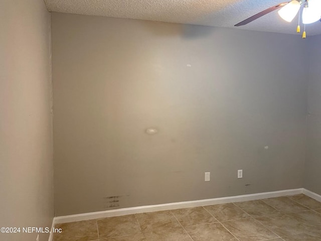 unfurnished room with ceiling fan, a textured ceiling, and light tile patterned floors