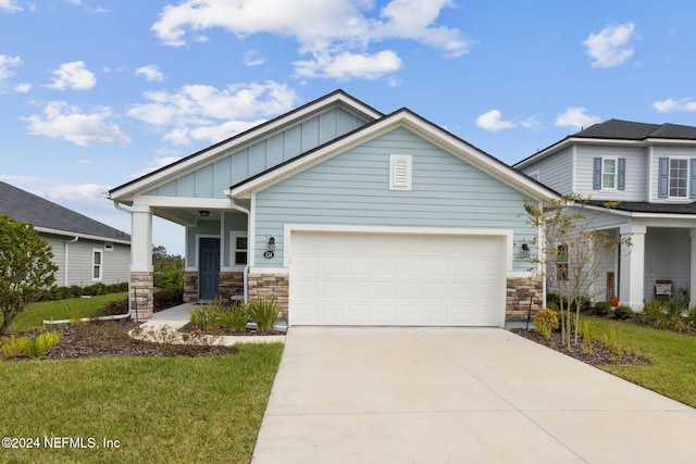 craftsman house with a front lawn, covered porch, and a garage