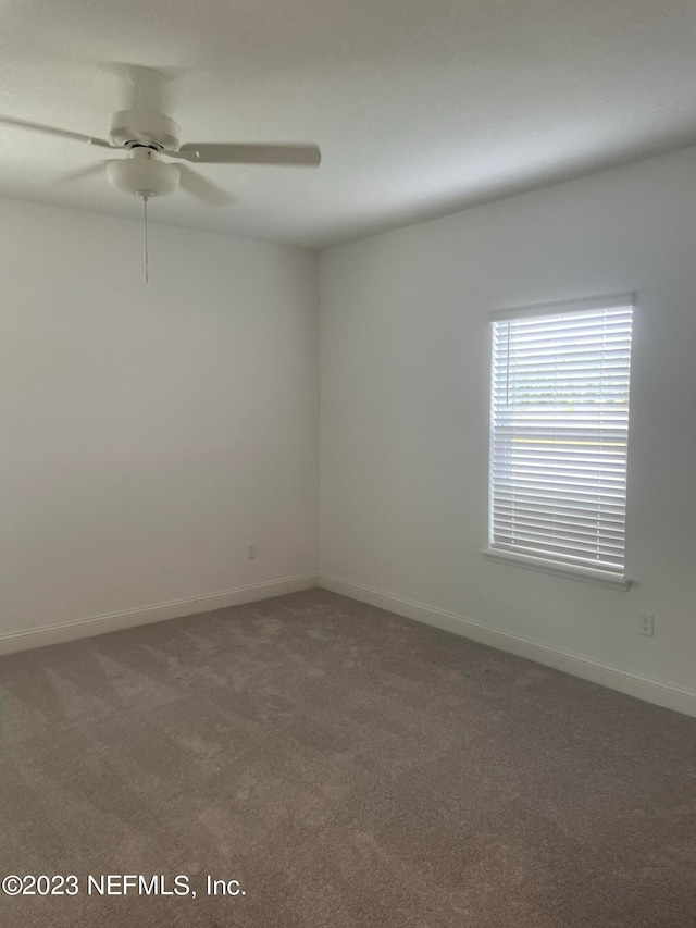 carpeted empty room featuring ceiling fan