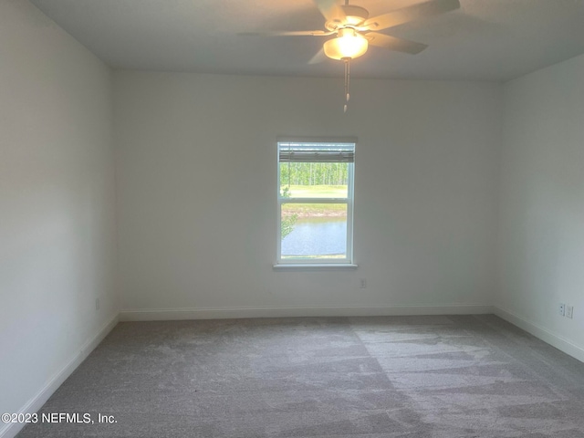 carpeted spare room with ceiling fan