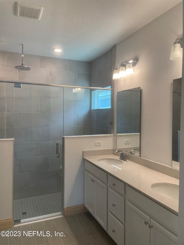 bathroom with vanity and a shower with door