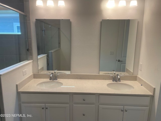 bathroom with vanity and a shower with door