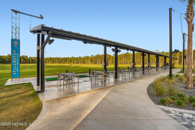 view of property's community featuring a patio and a lawn