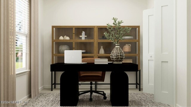 carpeted office space featuring baseboards