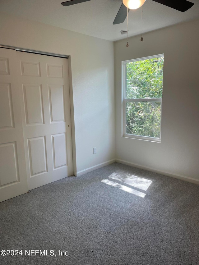 unfurnished bedroom with carpet floors, a closet, and ceiling fan