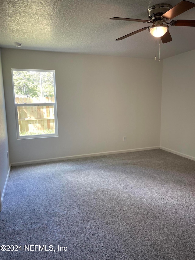 carpeted spare room with a textured ceiling and ceiling fan