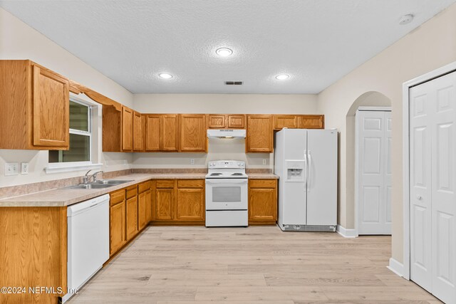 kitchen featuring light hardwood / wood-style flooring, a textured ceiling, sink, and white appliances