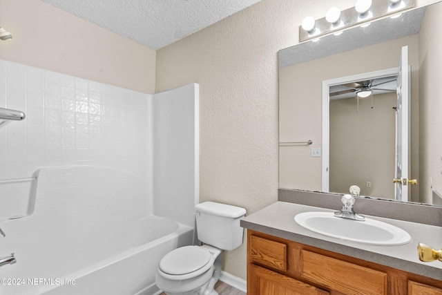 full bathroom featuring ceiling fan, a textured ceiling, toilet, vanity, and bathing tub / shower combination