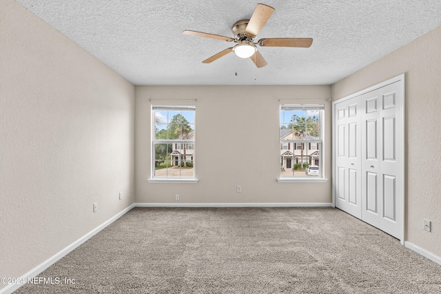 unfurnished bedroom with multiple windows, carpet, and ceiling fan