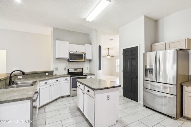 kitchen with stainless steel appliances, a textured ceiling, and white cabinets