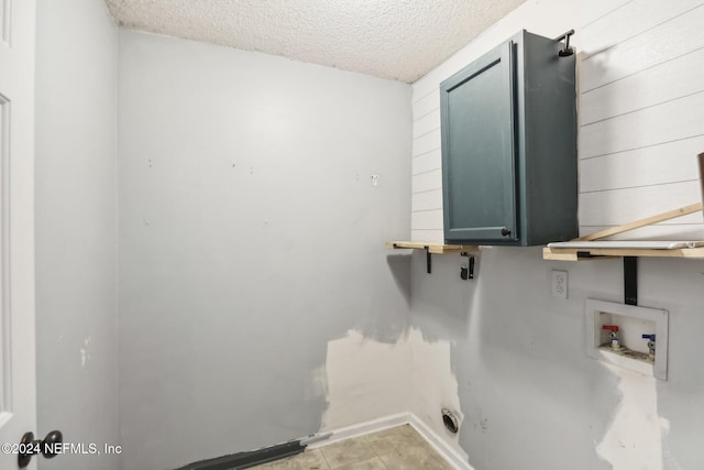 laundry area featuring cabinets, washer hookup, and a textured ceiling