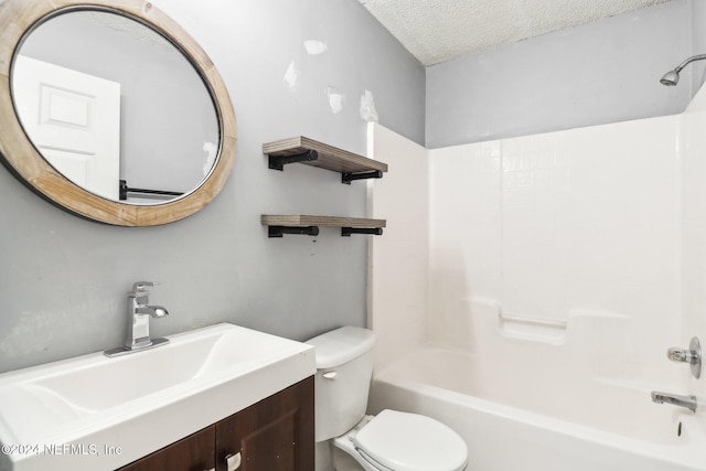 full bathroom featuring  shower combination, toilet, a textured ceiling, and vanity