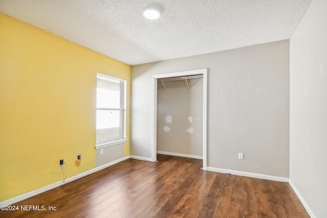 unfurnished bedroom featuring dark hardwood / wood-style flooring, a closet, and a textured ceiling