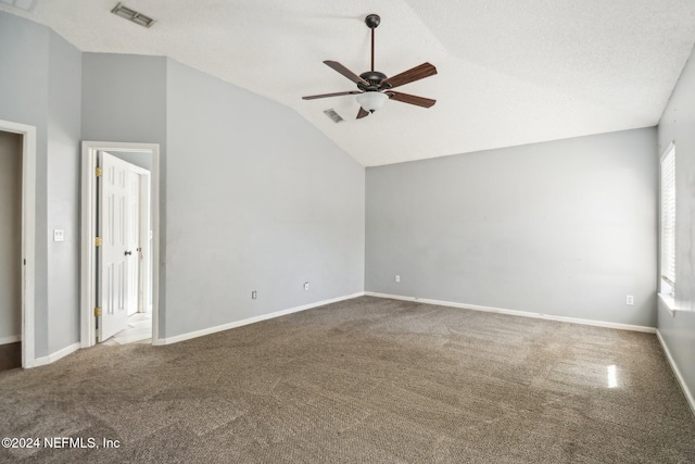 carpeted empty room with lofted ceiling, a textured ceiling, a wealth of natural light, and ceiling fan