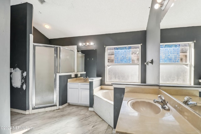 bathroom featuring plus walk in shower, vanity, and a textured ceiling