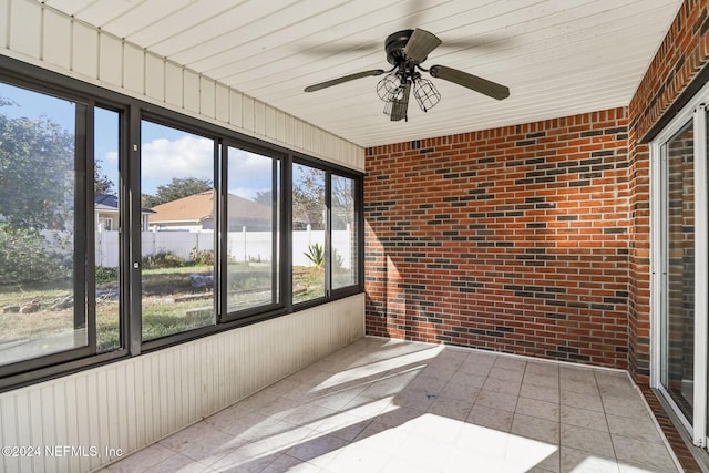 unfurnished sunroom with a water view and ceiling fan