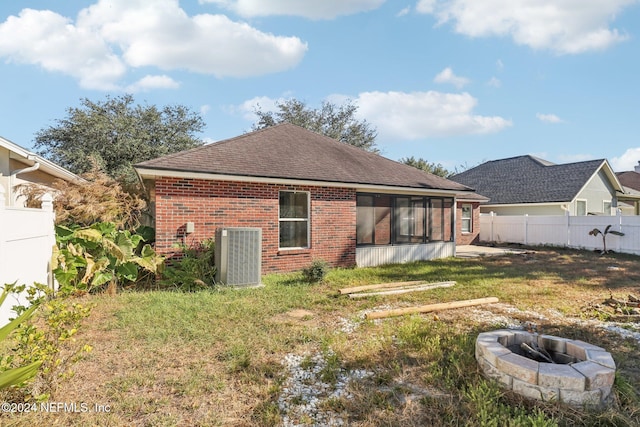 back of property featuring a yard, cooling unit, and an outdoor fire pit