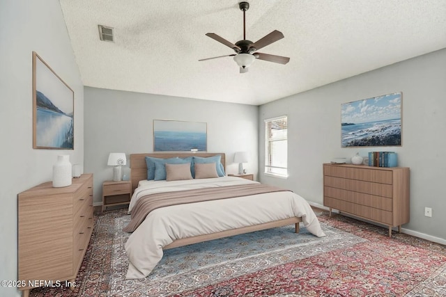 bedroom with ceiling fan and a textured ceiling