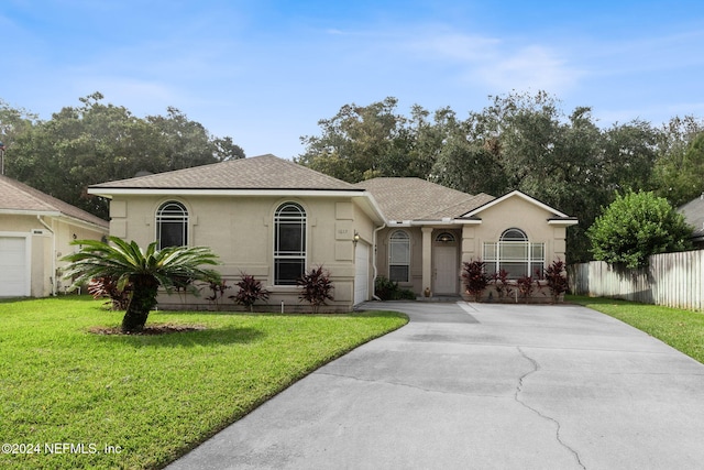 single story home featuring a garage and a front lawn