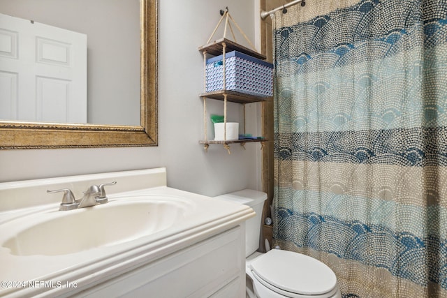 bathroom with vanity, curtained shower, and toilet