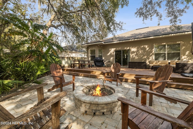 view of patio with grilling area, an outdoor living space with a fire pit, and a wooden deck