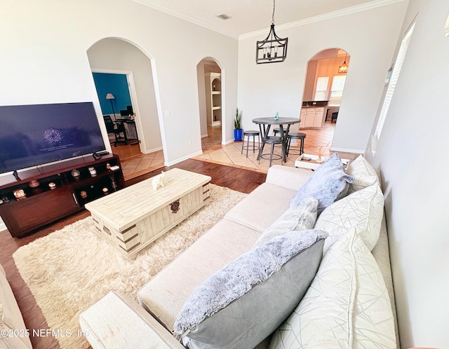 living room featuring tile patterned floors, an inviting chandelier, and crown molding