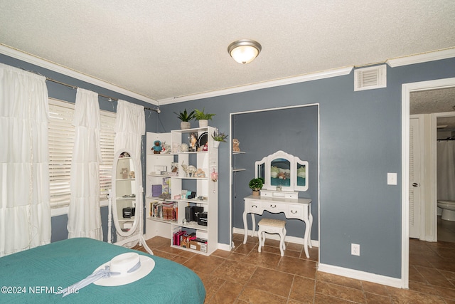 bedroom with ornamental molding, a textured ceiling, and dark tile patterned floors