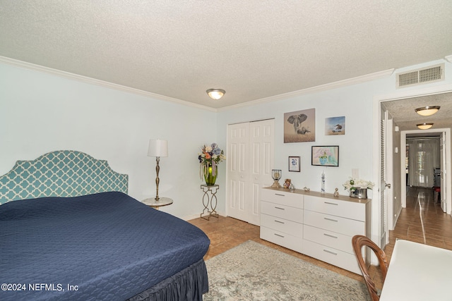 bedroom with a closet, a textured ceiling, and ornamental molding