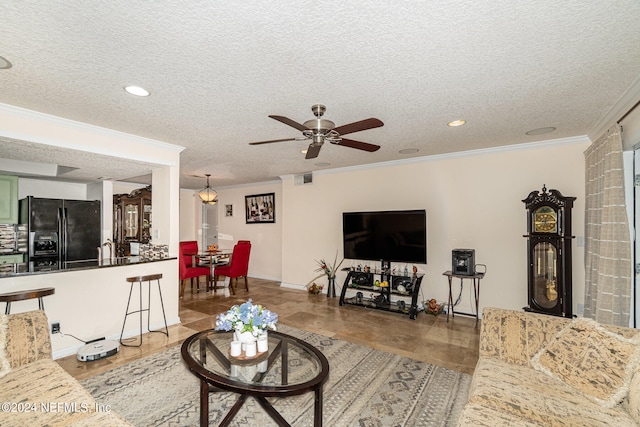 tiled living room featuring ornamental molding, sink, a textured ceiling, and ceiling fan