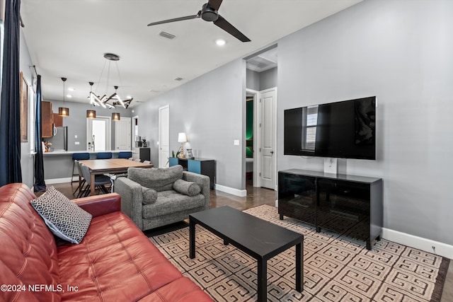 living room with ceiling fan with notable chandelier