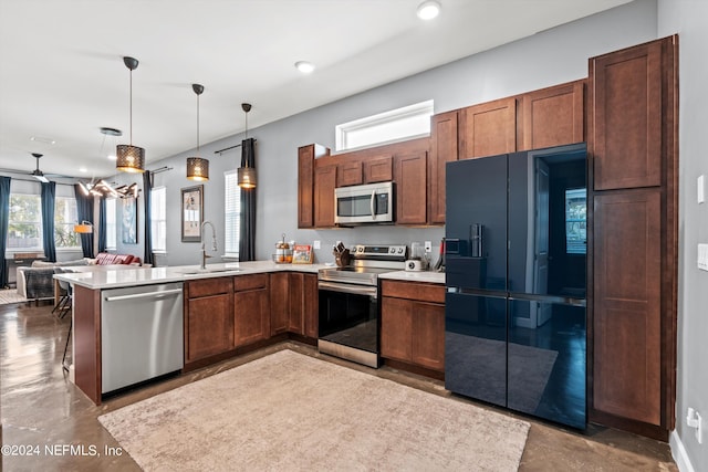 kitchen featuring a wealth of natural light, sink, appliances with stainless steel finishes, and kitchen peninsula