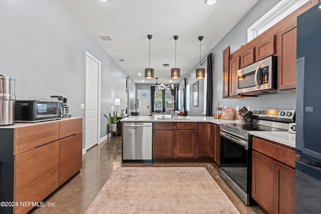 kitchen featuring stainless steel appliances, sink, concrete flooring, and pendant lighting