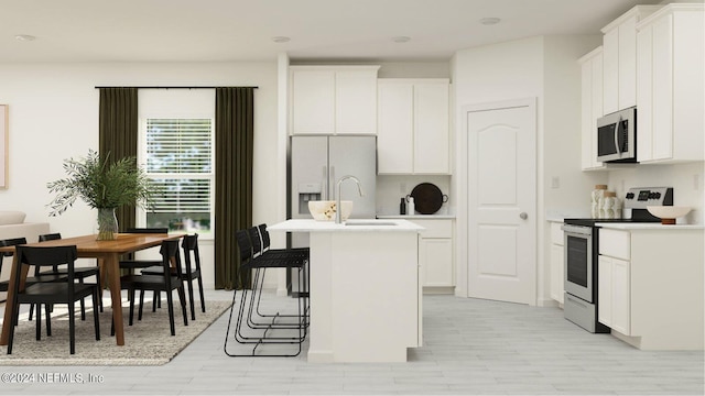 kitchen with a kitchen island with sink, a kitchen bar, stainless steel appliances, and white cabinetry