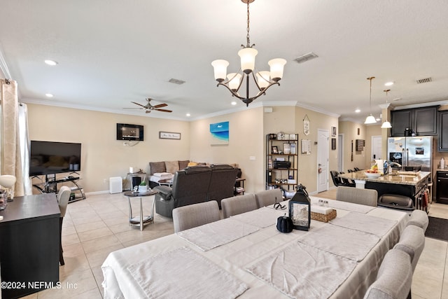 dining space with crown molding, ceiling fan with notable chandelier, and light tile patterned floors