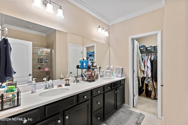 bathroom with a textured ceiling, a shower with shower door, vanity, crown molding, and tile patterned floors