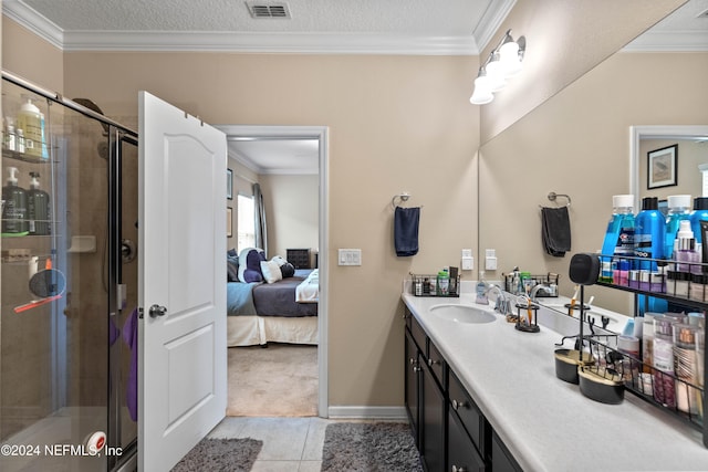 bathroom with vanity, tile patterned floors, a shower with shower door, and ornamental molding