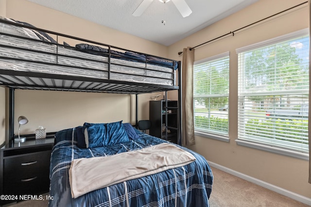 carpeted bedroom featuring a textured ceiling and ceiling fan