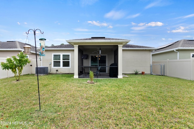 rear view of house featuring a yard, a sunroom, and central AC unit