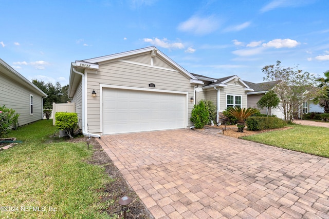 ranch-style house featuring a front lawn and a garage