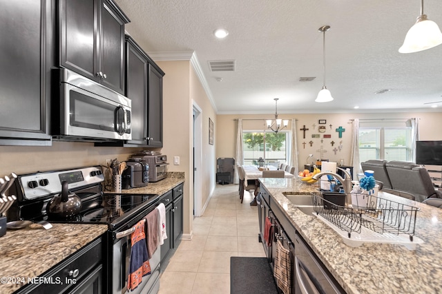 kitchen with light stone counters, a healthy amount of sunlight, appliances with stainless steel finishes, and decorative light fixtures